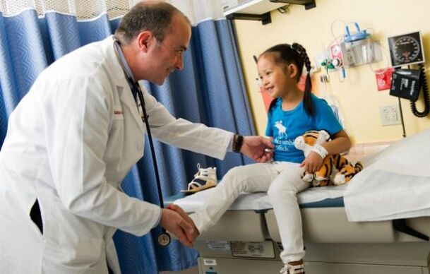 The doctor examines a child with hip osteoarthritis
